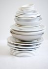Closeup view of assorted stacked dishes on white surface — Stock Photo