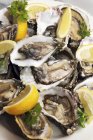 Fresh Irish oysters with lemon wedges — Stock Photo