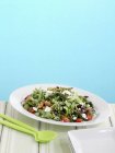 Весняний салат зі смаженою спаржею та кропом на білій тарілці над столом з ложкою — стокове фото