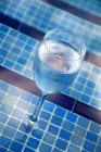Glass of water by the pool — Stock Photo
