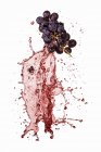 Uvas rojas con salpicaduras de vino - foto de stock