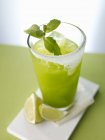 Vue rapprochée du cocktail Green Dream avec glaçons, menthe et quartiers de lime — Photo de stock