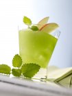 Closeup view of Frozen Apple cocktail with apple slices and leaves — Stock Photo