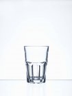 Vista da vicino di un bicchiere con acqua rimane sulla superficie bianca — Foto stock