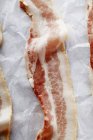 Bandes de bacon sur papier parchemin — Photo de stock