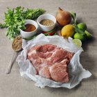 Carne di maiale cruda con ingredienti per arrostire — Foto stock