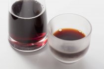 Soy sauce in a bottle and in a glass on a white surface — Stock Photo