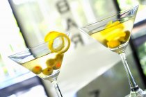 Грязный мартини с оливками и лимонной цедрой — стоковое фото