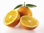 Oranges fraîches avec moitiés — Photo de stock