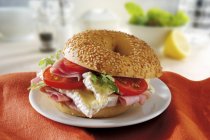 Sesame seed bagel with brie and tomatoes — Stock Photo