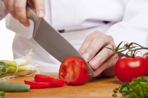 Chef Slicing red tomatoes — Stock Photo