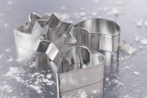 Closeup view of assorted cookie cutters with flour — Stock Photo