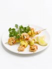 Prawn and pineapple kebabs on white plate — Stock Photo