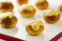Closeup view of gratinated mini Brioches on white surface — Stock Photo