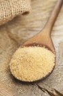 Unrefined cane sugar on wooden spoon — Stock Photo