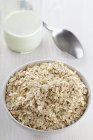 Closeup view of an oats bowl in front of a bottle of milk — Stock Photo