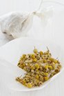 Camomile flowers in teabag — Stock Photo