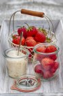 Strawberries in basket and sugar in bowl — Stock Photo
