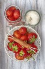 Erdbeeren im Korb und Zucker in Schüssel — Stockfoto