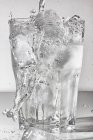 Agua vertida en un vaso de hielo - foto de stock