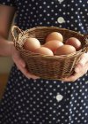 Жінка тримає кошик зі свіжих яєць — стокове фото