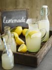 Lemonade in bottles and jug — Stock Photo