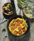 A tomato omelette with sage, black and green olives, olive oil, an olive spring, olive ciabatta and lavender — Stock Photo