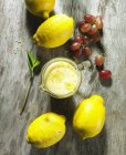 Primer plano vista superior de limón y salsa de espuma de vino con ralladura de limón y uvas - foto de stock