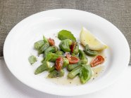 An okra medley with cherry tomatoes  on white plate — Stock Photo