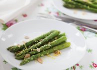 Asparagus with lemon and slivered almonds — Stock Photo