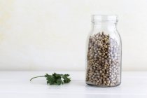 Coriander seeds in glass jar — Stock Photo