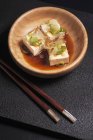Vista de cerca del tofu de seda fría Hiyayakko con hojuelas de Bonito, cebollino, jengibre rallado y salsa de soja - foto de stock