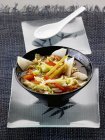 Cavolo a punta con verdure e citronella in ciotola nera su piatto bianco — Foto stock