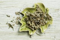 Top view of dried mugwort with flowers in a leaf-shaped bowl — Stock Photo