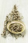Mugwort with flowers in a bowl and on a wooden surface — Stock Photo
