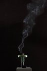 Closeup view of a smoking incense cone on black background — Stock Photo