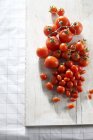 Various tomatoes on wooden board — Stock Photo