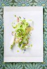 Салат из сельдерея и редиса на белой тарелке поверх ткани — стоковое фото