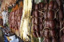 Крупный план камбоджийских колбас и других сушеных колбас на рынке — стоковое фото