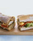 Сэндвич с багетом и рыбой на деревянном столе — стоковое фото