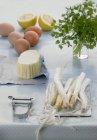 Asparagus and ingredients for Sauce Hollandaise on table with cloth — Stock Photo