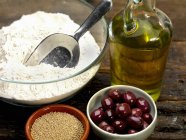 Ingredienti per focaccia con olive in ciotole su superficie di legno — Foto stock