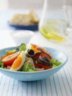 Salad nioise on blue plate over tablecloth — Stock Photo