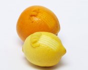 Orange and lemon with curling zest — Stock Photo