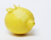 Fresh lemon with curling zest — Stock Photo