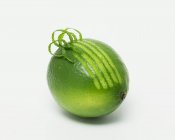 Fresh lime with curling zest — Stock Photo