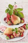 Bayas y rosas en soporte de pastel - foto de stock