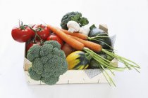 Una caja de verduras ecológicas sobre fondo blanco - foto de stock