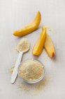 Vista ravvicinata di polvere di frutto di mango in una ciotola di vetro e su un cucchiaio — Foto stock
