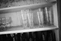 Vista inclinada de óculos empilhados em uma prateleira de madeira — Fotografia de Stock